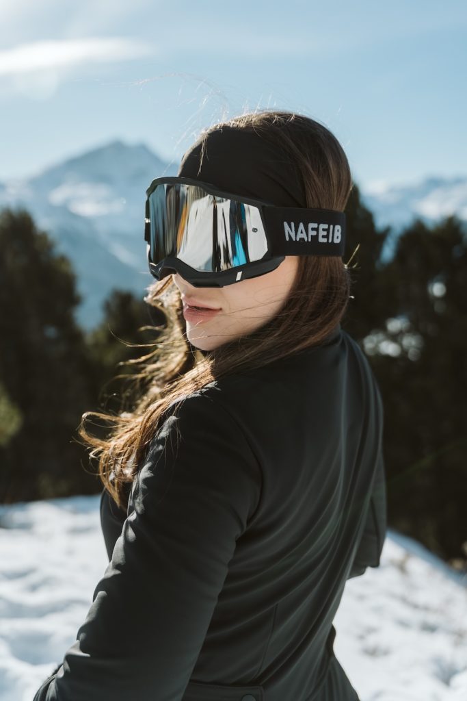 Editorial winter portrait with black outfit and alpine mountain background