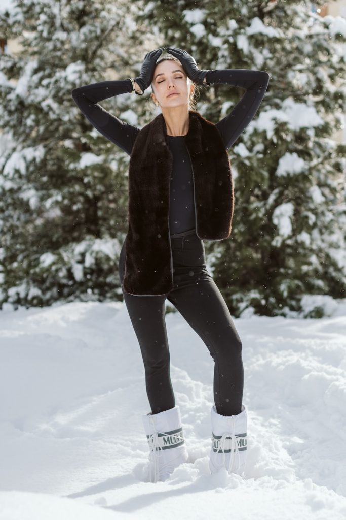 Editorial winter portrait with black outfit and alpine mountain background