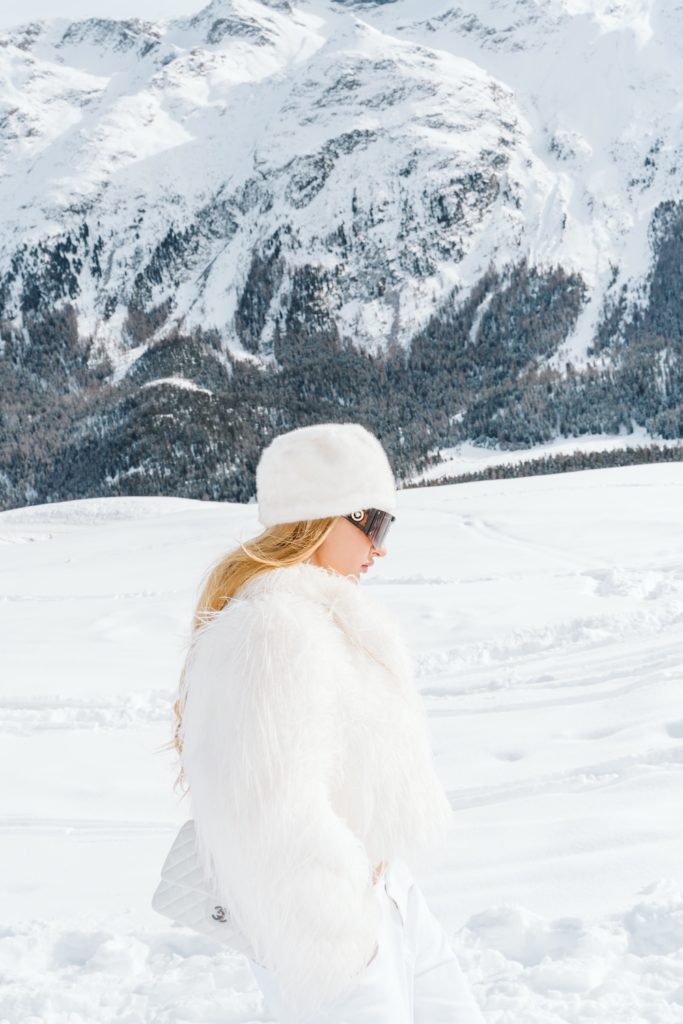 Side profile fashion portrait with snowy mountain backdrop in St. Moritz